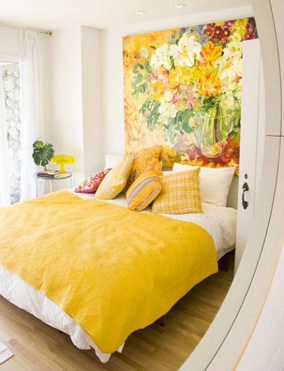 a colorful statement wall with an oversized artwork and matching pillows and a bedspread for summer