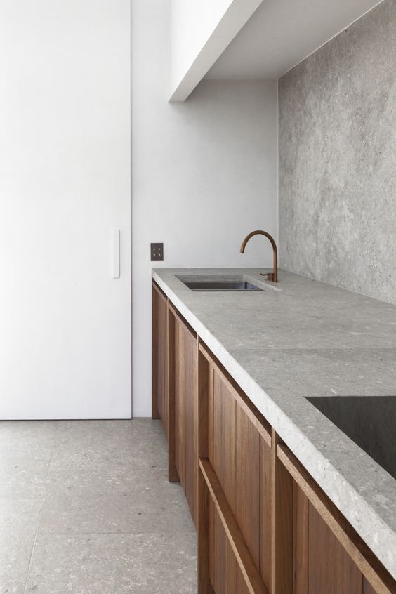 A two toned modern kitchen in white with a concrete backsplash and countertops
