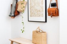 22 a simple wooden bench, a metal basket, an artwork, a cascading plant and a vintage camera