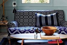 23 a bold sofa with a windowpane pinted back and armrests and a geometric print seat  plus a striped pillow