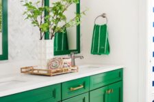23 an emerald sink stand and framed mirrors add color to the space and are spruced up with brass touches
