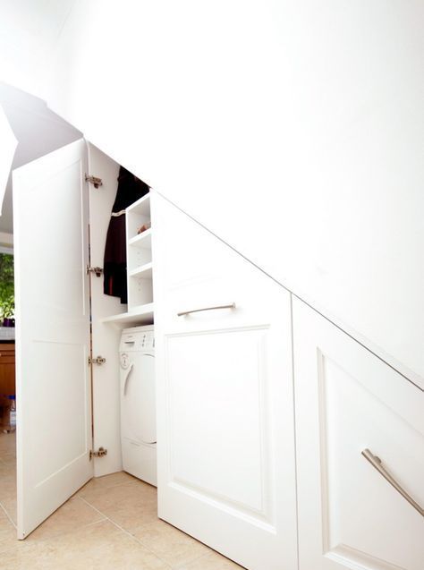 a built-in laundry space under the stairs with much storage for the things