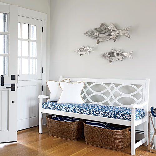 a vintage upholstered bench, baskets for storage and a wooden fish arrangement for decor