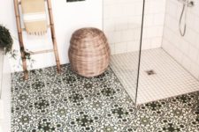 25 a wooden floor, a ladder as a towel rack, a basket for storage and mosaic tiles on the floor