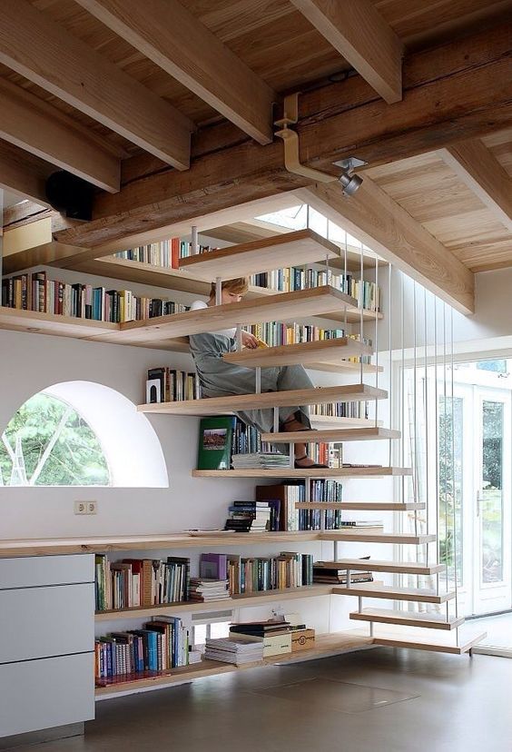 bookshelves covering the wall and under the space under the stairs is an effective solution