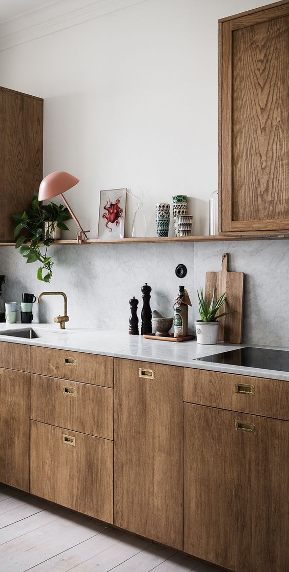 rich-colored wooden cabinets with grey marble tiles for the backsplash and countertops