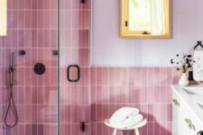 a bathroom with lilac walls and pink skinny and leaf-shaped tiles, a shower space, a white vanity and greenery is lovely