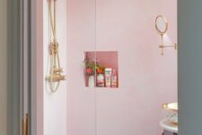 a light pink bathroom with a rounded vanity, a niche shelf, some gold fixtures is a pretty and fun idea, and a skylight adds natural light
