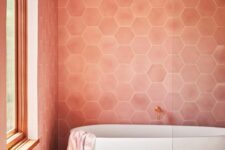 a light pink bathroom with hex tiles, an oval tub, a shower space is a warm and welcoming space