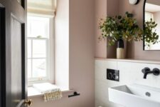 a mauve and white bathroom with white appliances, black fixtures and greenery is amazing for a modern home