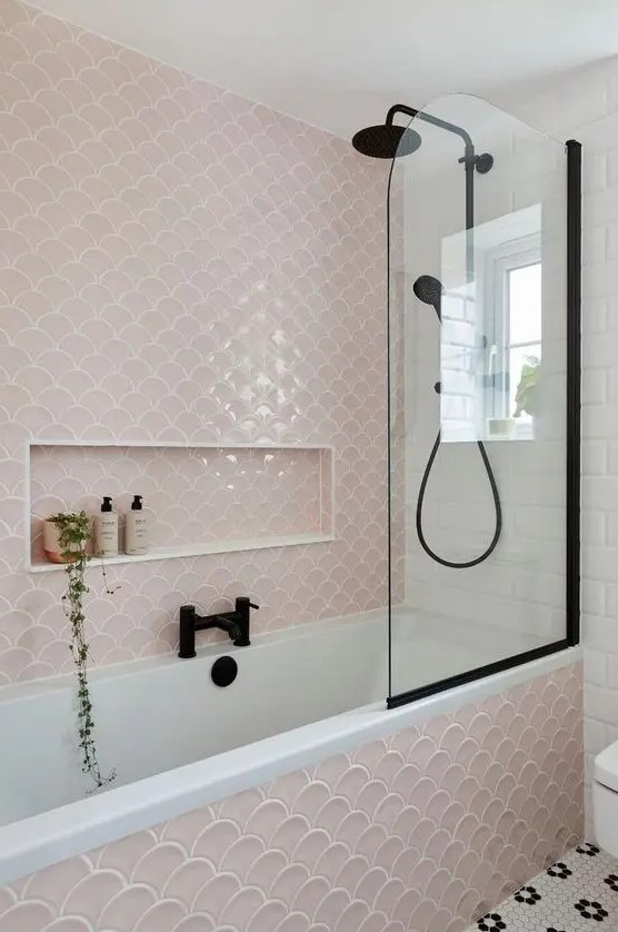 a modern bathroom in blush, white and black, with fishscale tiles, black fixtures and penny ones on the floor