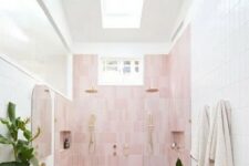 a neutral bathroom with a skylight, a pink accent wall, a floating vanity, pink sinks and potted plants