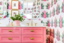 the whimsical pineapple wallpaper and bright pink color scheme in this bathroom screams Palm Beach