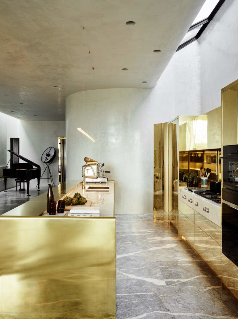 The kitchen has a strong wow factor, it's done with brass, marble and concrete, it shines from a distance