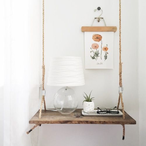 a cute swing-style nightstand of wood and rope brings a cute summer feel to the space