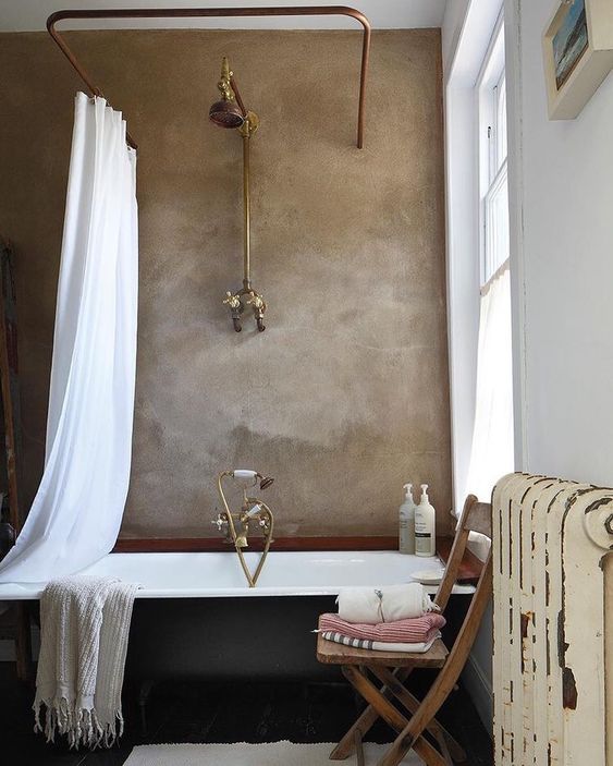 a taupe plaster wall in the bathroom makes a stylish statement and metallic touches add a vintage feel