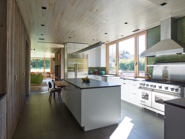 The kitchen is done with white cabinets, there's a large window that lets the views