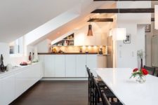 03 a contemporary attic kitchen in white with some dark touches and cabinets that fit the angle