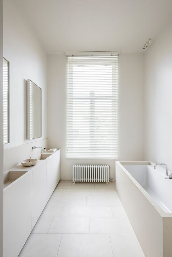 a creamy bathroom with a covered bathtub and a double vanity looks clean