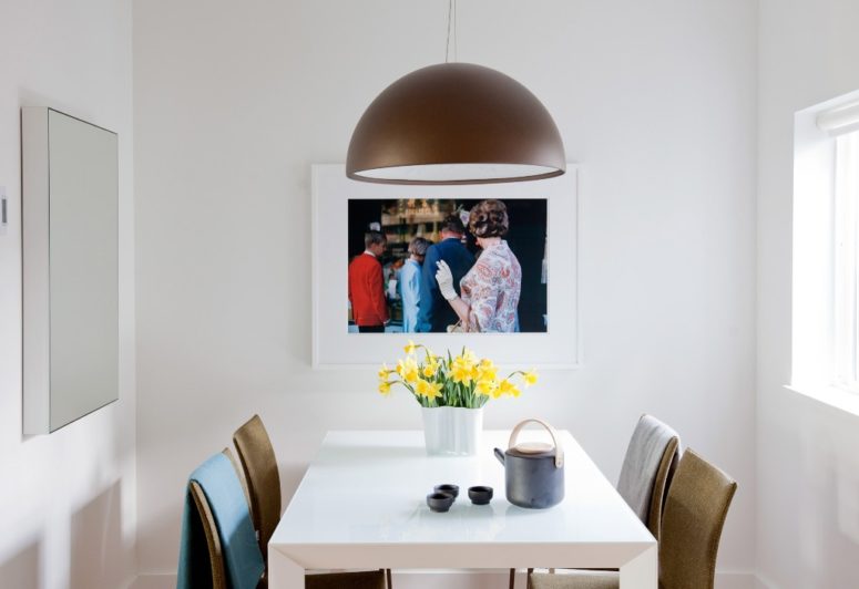The dining zone features a comfy area for four people and an artwork plus a stylish pendant lamp