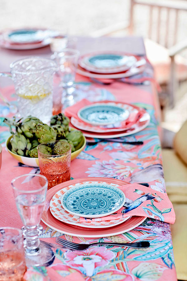 You may find coral pink tablecloths with floral prints, napkins with paradise birds and colorful plates