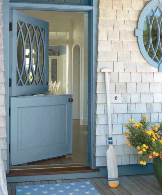 A blue Dutch door with a creative glass top part and shingles look cool together