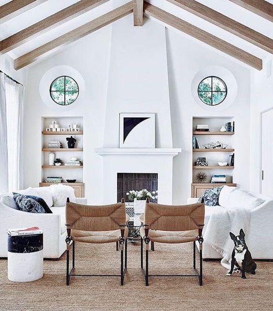 a chic small living room done in white with two white couches and touches of wood and wicker for a fresh farhouse look