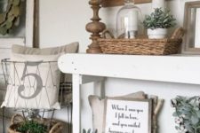04 a farmhouse console table with a basket, much greenery in vases and some antique finds