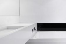 04 an ultra-minimalist white bathroom with a black built-in fireplace and a long vanity