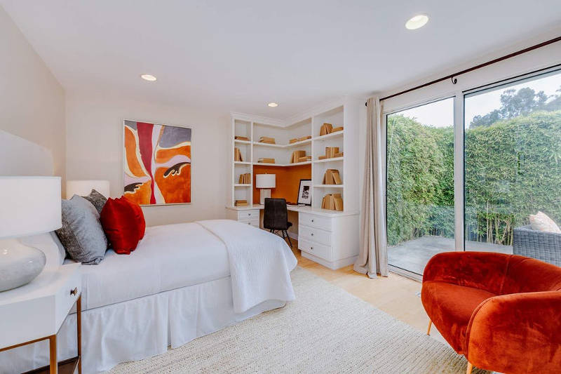 The second bedroom is accented with orange touches and looks very bright and shining
