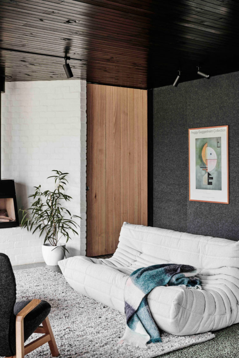 Touches of wood, a cool rug, greenery and an artwork make the space cooler