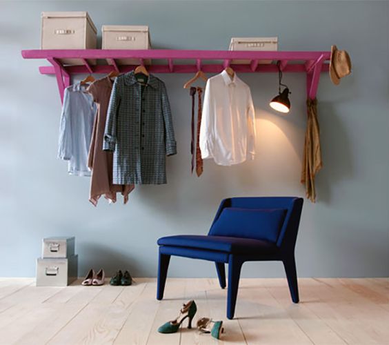a fun and colorful wall-mounted shelf of a ladder painted pink for a modern and bold statement