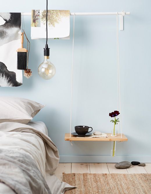 a low hanging bedside table styled as a swing of rope and a wood plaque for a contemporary space