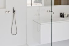 05 a minimalist white bathroom with a seamless shower, a long mirror and clean lines