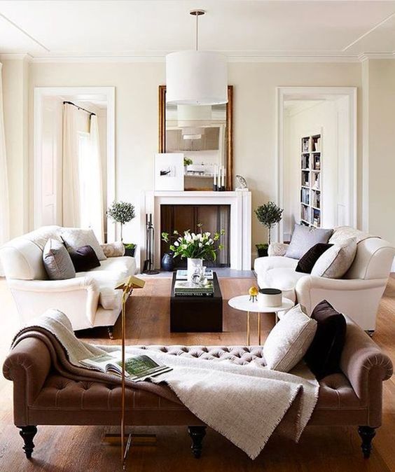 a refined living room with two white sofas and a tufted daybed for a luxurious feel