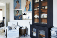 06 The black armoire is a vintage French piece and colorful art contrasts it