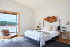 06 The master bedroom shows off an amazing view and a comfy bed with a rough wooden sculpture