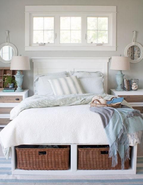 a beach cottage guest bedroom with a bed with storage baskets inside is a genius idea