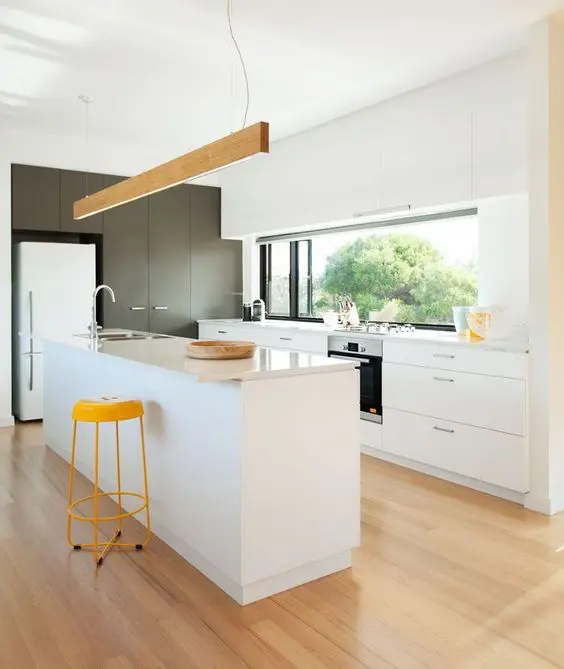 a contemporary white kitchen with touches of yellow and wood plus a window backsplash