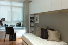 06 a small contemporary bedroom with a sleeping space, cabinets for storage and a glass windowsill