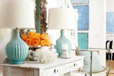 06 a whitewashed console table, a coral, turquoise lamps and a mirror clad with driftwood