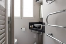 07 The bathroom is a tiny neutral space with a wall-mounted sink