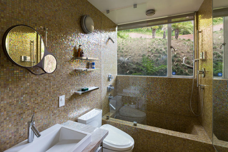 The bathroom is done with sparkling beige tiles and features a window