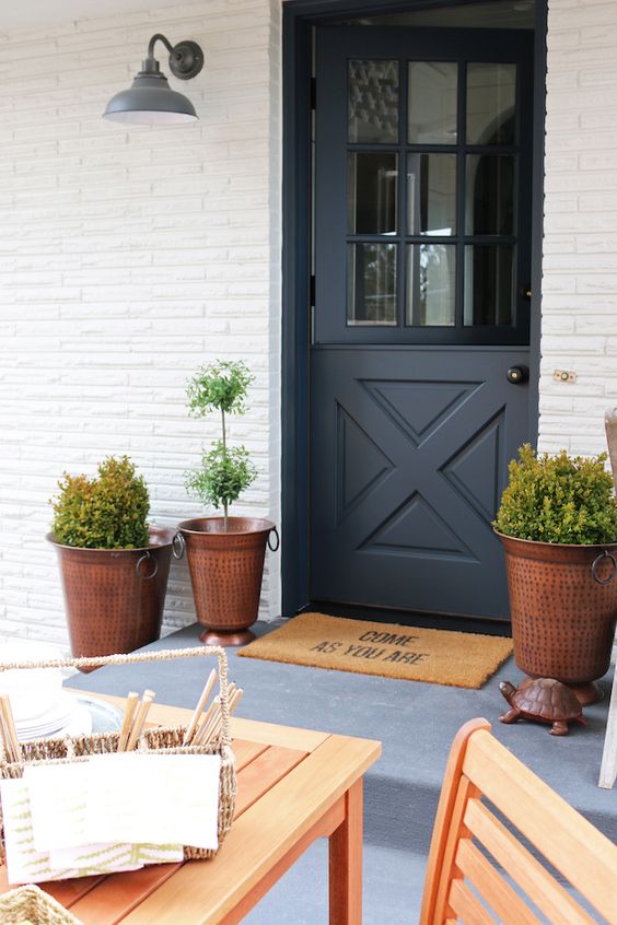 a chic entrance with hammered copper planters and a graphite grey Dutch door