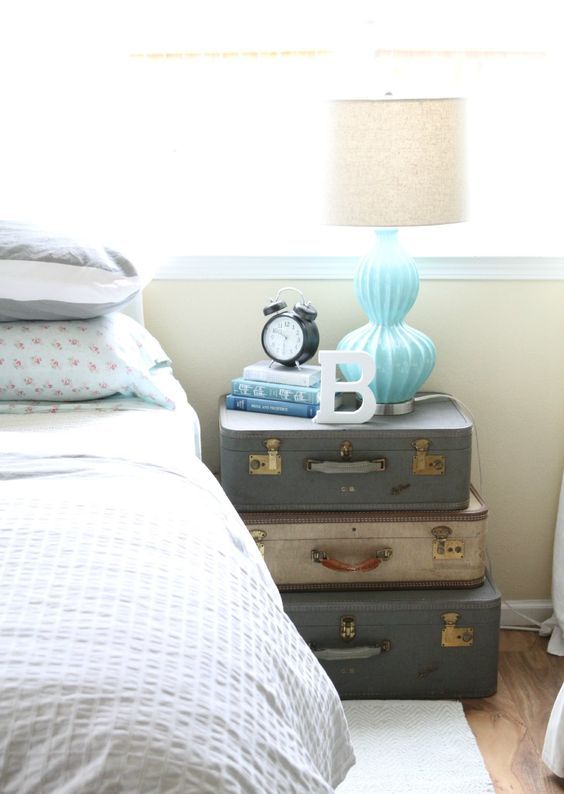a stack of vintage suitcases highlights the rustic vintage style of the bedroom