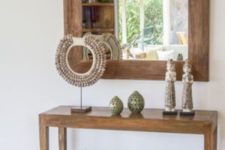 07 a wooden console with travel finds from the East and greenery in baskets under it