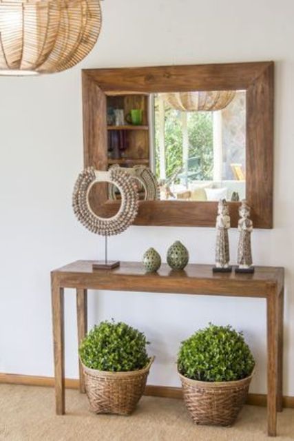 a wooden console with travel finds from the East and greenery in baskets under it