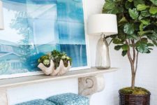 08 a beach-inspired console, a shell planter, a glass vase and a large seaside-inspired artwork