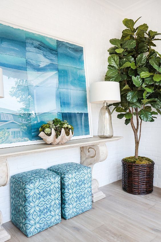 a beach-inspired console, a shell planter, a glass vase and a large seaside-inspired artwork