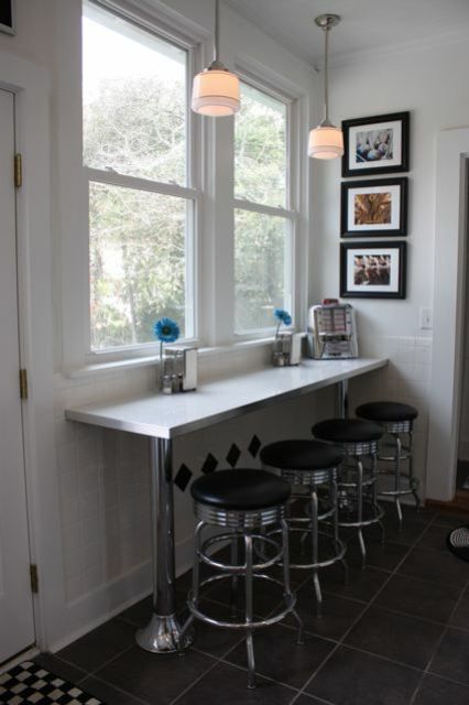 a small breakfast bar with a windowsill table and some industrial stools for a cozy feel